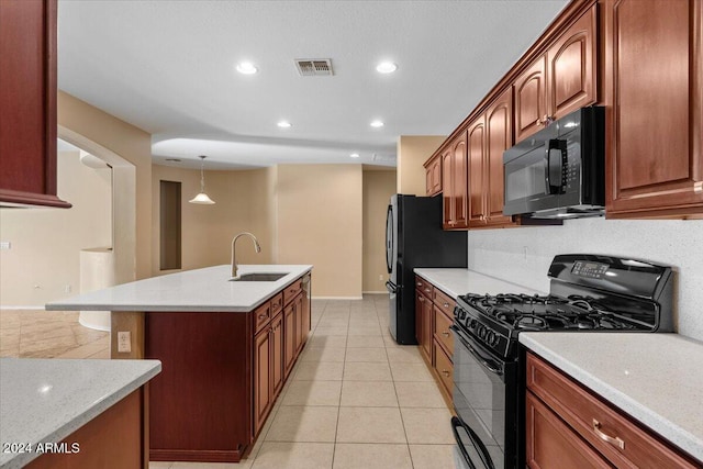 kitchen featuring sink, decorative light fixtures, a center island with sink, light tile patterned floors, and black appliances