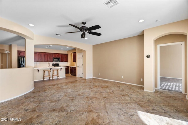 unfurnished living room featuring ceiling fan