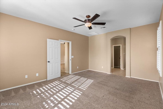 carpeted spare room featuring ceiling fan