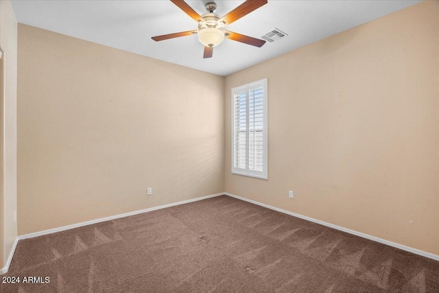 carpeted spare room featuring ceiling fan