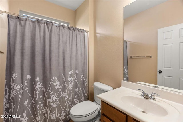 bathroom with a shower with shower curtain, vanity, and toilet