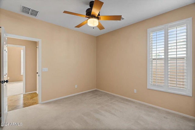 carpeted spare room featuring ceiling fan