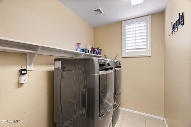 laundry room featuring separate washer and dryer and light tile patterned floors