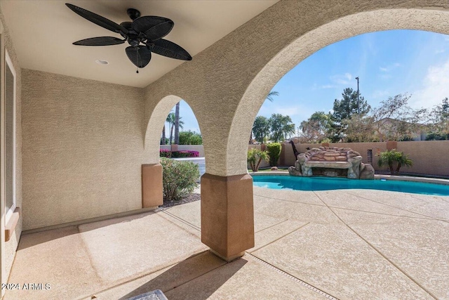 view of swimming pool featuring ceiling fan and a patio area