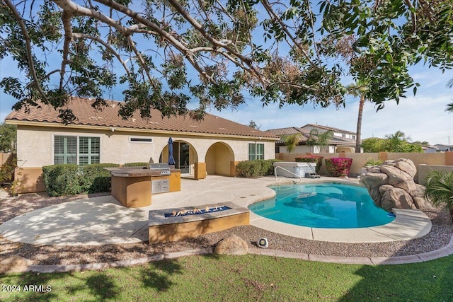 back of house with a fenced in pool, a patio area, and area for grilling