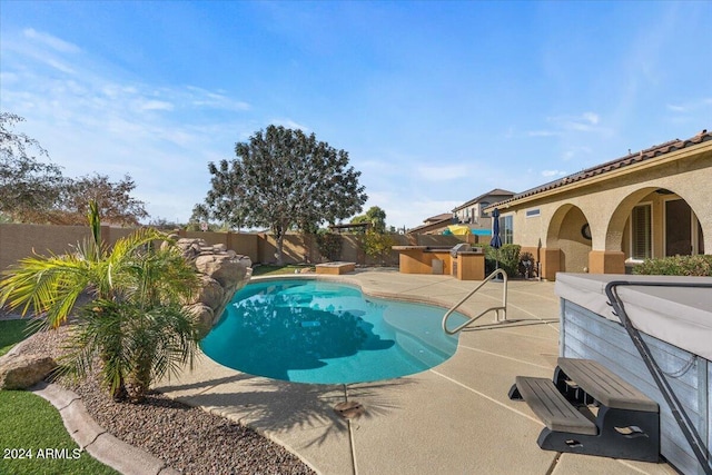 view of pool featuring a patio area and exterior kitchen