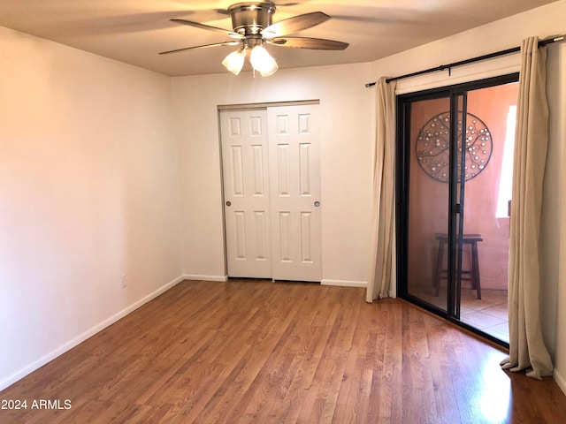 unfurnished bedroom with wood-type flooring, a closet, and ceiling fan