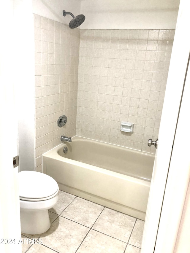 bathroom featuring tile patterned floors, tiled shower / bath combo, and toilet