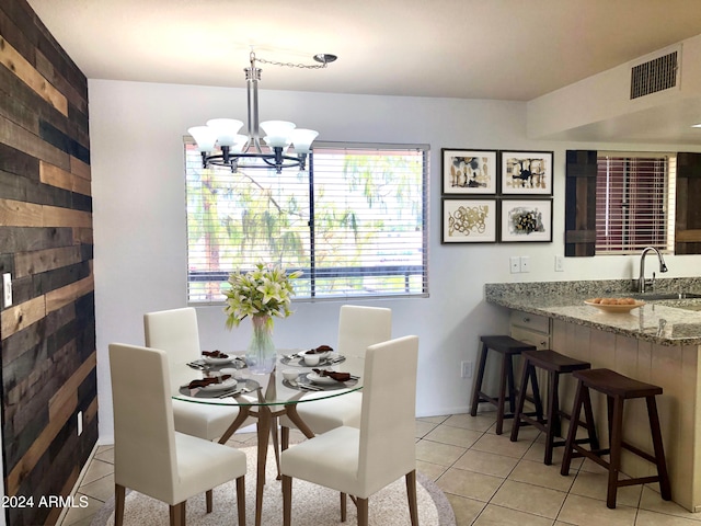 dining space with light tile patterned floors, a notable chandelier, and sink