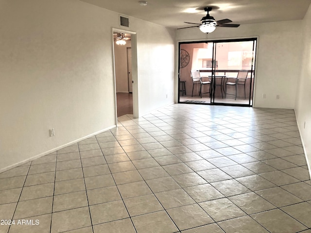 tiled empty room featuring ceiling fan