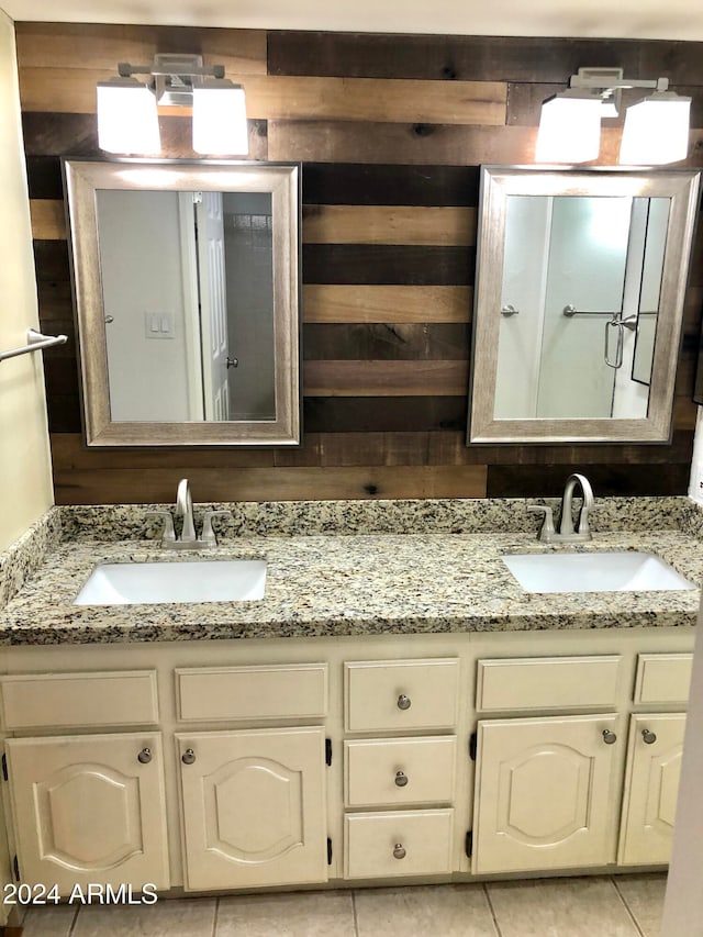 bathroom with tile patterned floors, wooden walls, and vanity