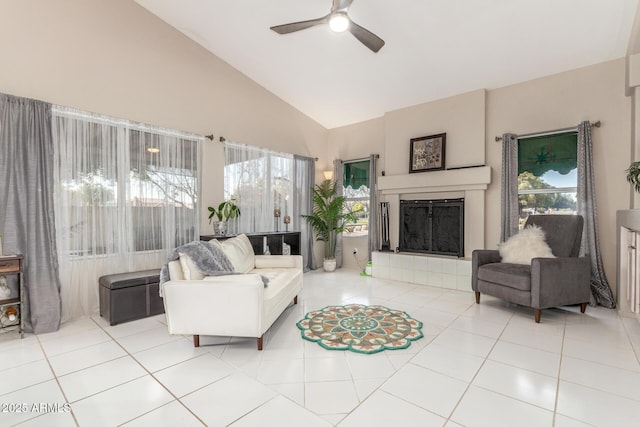 tiled living room featuring a fireplace, high vaulted ceiling, and ceiling fan