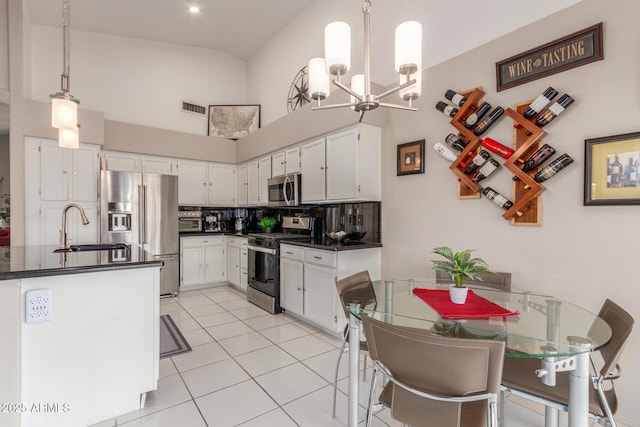 kitchen with sink, light tile patterned floors, appliances with stainless steel finishes, pendant lighting, and white cabinets