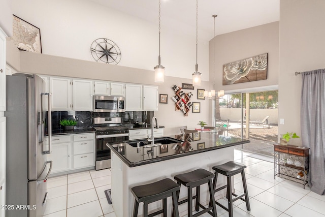 kitchen featuring pendant lighting, appliances with stainless steel finishes, sink, and white cabinets