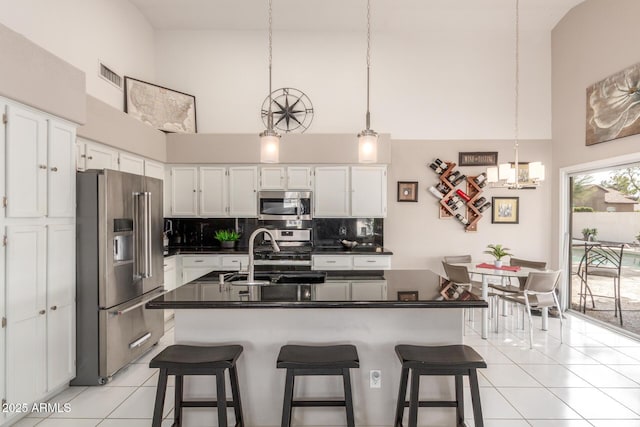 kitchen featuring appliances with stainless steel finishes, a kitchen bar, and white cabinets