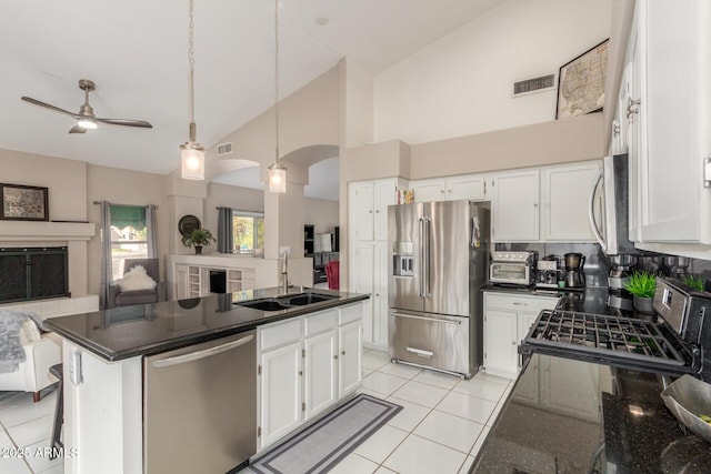 kitchen featuring appliances with stainless steel finishes, white cabinetry, sink, hanging light fixtures, and light tile patterned floors