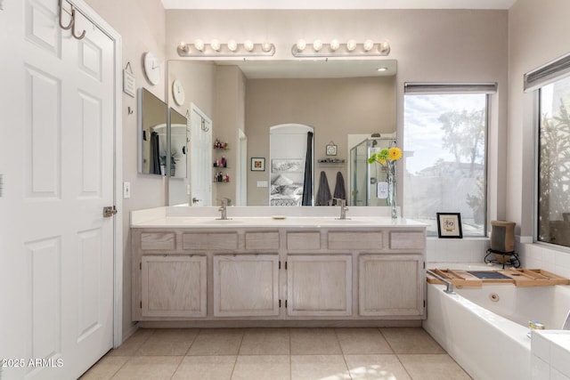 bathroom featuring tile patterned floors, vanity, and shower with separate bathtub