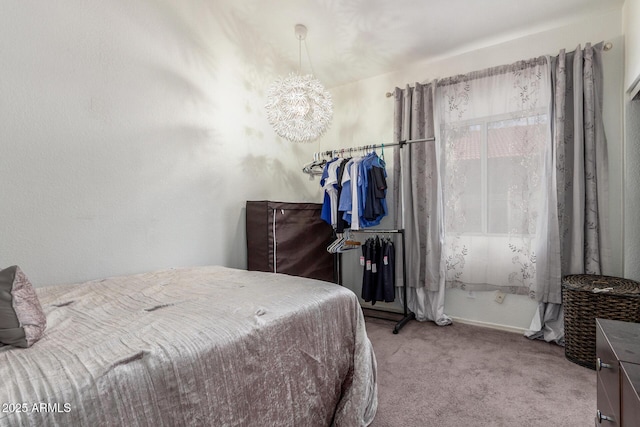 bedroom with a notable chandelier and light colored carpet