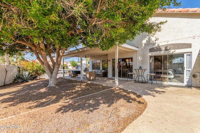 back of property with an outdoor living space and a patio