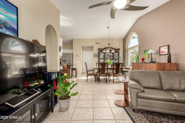 living room featuring ceiling fan, lofted ceiling, and light tile patterned flooring