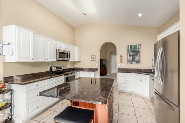 kitchen featuring sink, white cabinets, dark stone counters, a center island, and stainless steel appliances