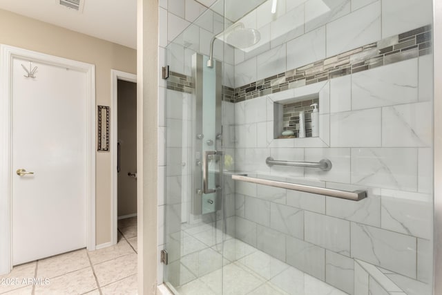 bathroom featuring a shower with door and tile patterned flooring