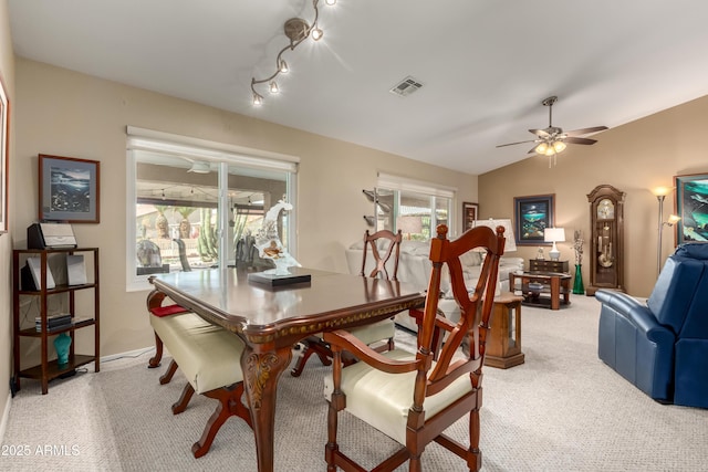 carpeted dining area with vaulted ceiling and ceiling fan