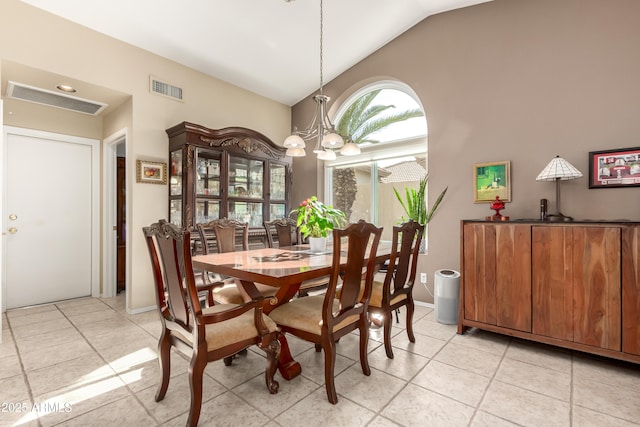 tiled dining area with an inviting chandelier and vaulted ceiling