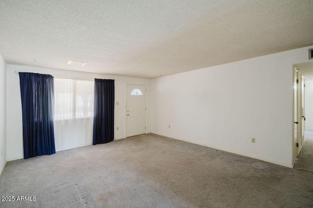 empty room featuring visible vents, carpet floors, and a textured ceiling