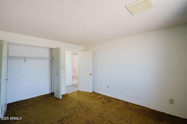 unfurnished bedroom featuring a closet, visible vents, a textured ceiling, and carpet floors