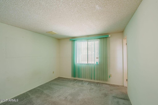 carpeted empty room featuring visible vents and a textured ceiling