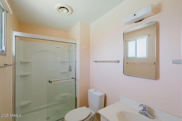 bathroom with vanity, a shower stall, and toilet