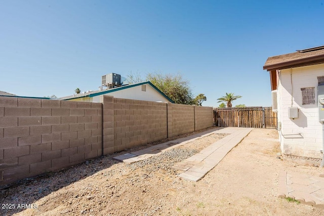 view of yard with cooling unit and a fenced backyard