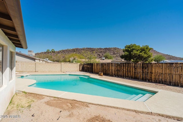 view of pool with a fenced in pool, a mountain view, and a fenced backyard