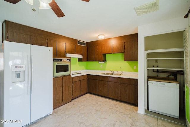 kitchen featuring visible vents, white appliances, light countertops, and a sink