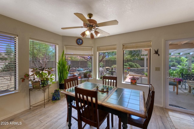 dining room with light wood-style floors, baseboards, and a ceiling fan