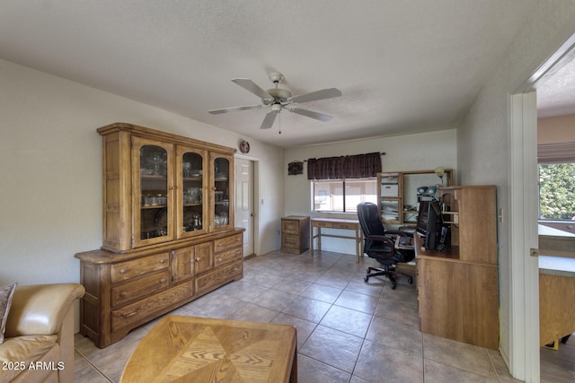 home office with ceiling fan, a textured ceiling, a wealth of natural light, and light tile patterned floors