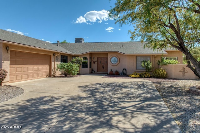 ranch-style house with roof with shingles, an attached garage, stucco siding, and driveway