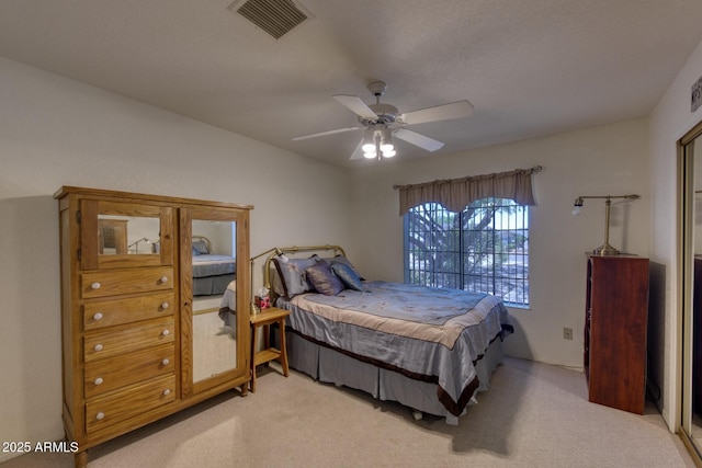 bedroom with ceiling fan, light carpet, and visible vents