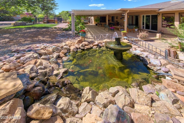 exterior space featuring a small pond and fence