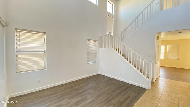 7425 W Crown King Rd, Phoenix, AZ 85043 - unfurnished living room featuring stairway, a towering ceiling, baseboards, and wood finished floors