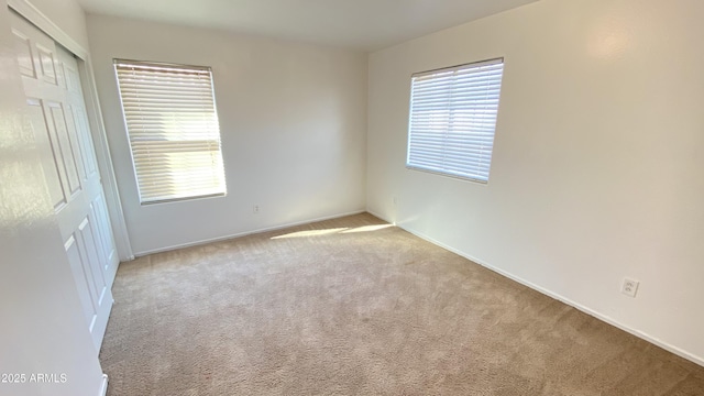 7425 W Crown King Rd, Phoenix, AZ 85043 - empty room featuring carpet, a healthy amount of sunlight, and baseboards