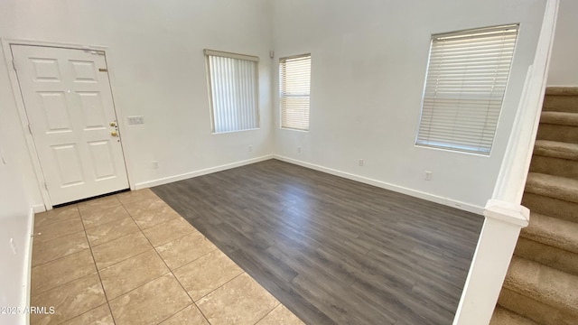7425 W Crown King Rd, Phoenix, AZ 85043 - foyer entrance featuring a towering ceiling, dark tile patterned flooring, baseboards, and stairs