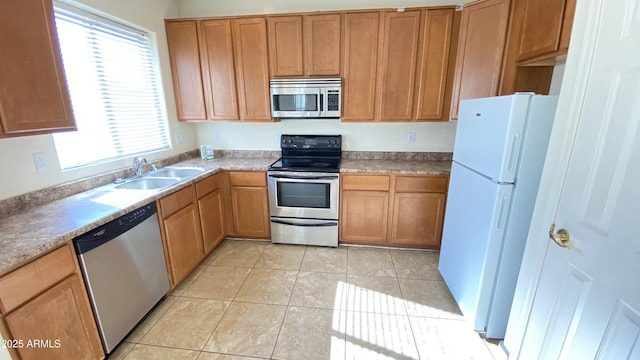7425 W Crown King Rd, Phoenix, AZ 85043 - kitchen with brown cabinetry, appliances with stainless steel finishes, light tile patterned floors, and a sink