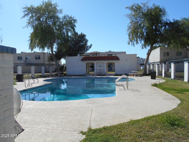 pool with a patio area and fence