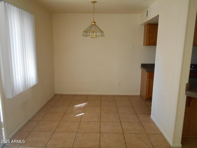 unfurnished dining area with light tile patterned floors, visible vents, and baseboards