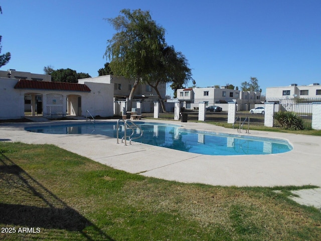 community pool with a residential view, a patio, and fence