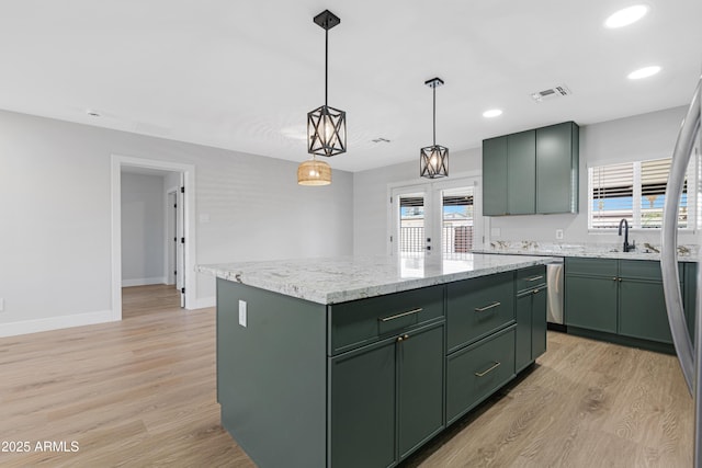 3607 N 79th Ave, Phoenix, AZ 85033 - kitchen featuring green cabinetry, light wood-style floors, a kitchen island, a sink, and baseboards
