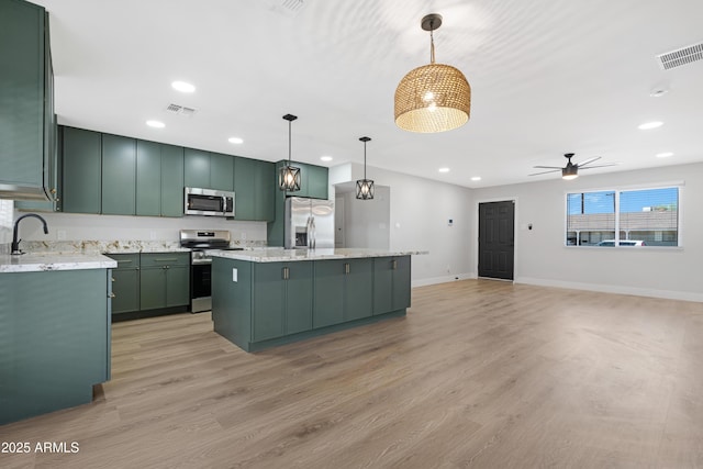 3607 N 79th Ave, Phoenix, AZ 85033 - kitchen with appliances with stainless steel finishes, green cabinetry, a center island, ceiling fan, and light wood-style floors