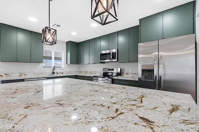 3607 N 79th Ave, Phoenix, AZ 85033 - kitchen featuring green cabinets, appliances with stainless steel finishes, light stone counters, a sink, and recessed lighting